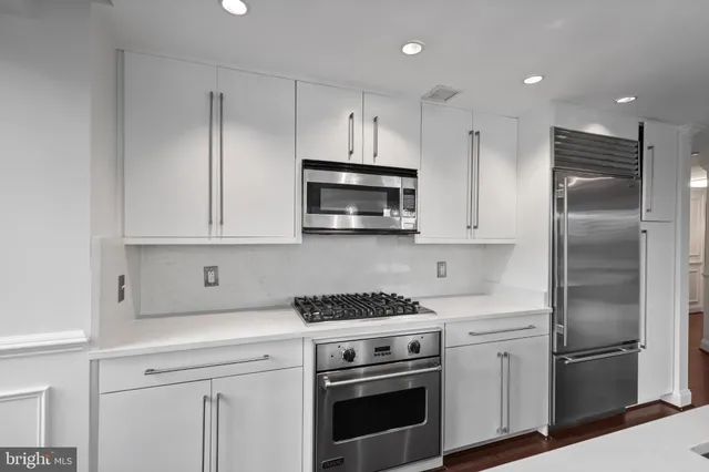 a kitchen with stainless steel appliances a refrigerator sink and stove