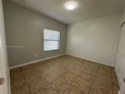 an empty room with a white door and a window