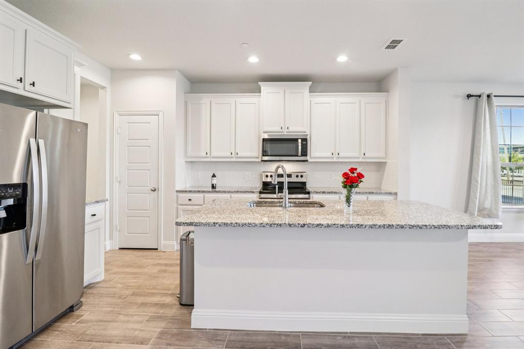 6000 Bursey Road Watauga, TX 76148 - Photo 5 of 13 a kitchen with granite countertop a refrigerator and a sink