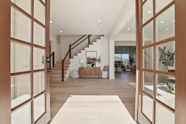 a living room with furniture a fireplace and a dining table with wooden floor