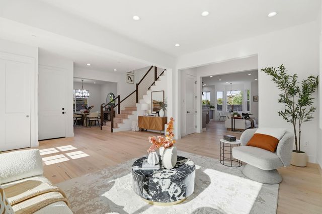 a kitchen with stainless steel appliances kitchen island granite countertop a sink a counter top space and living room view