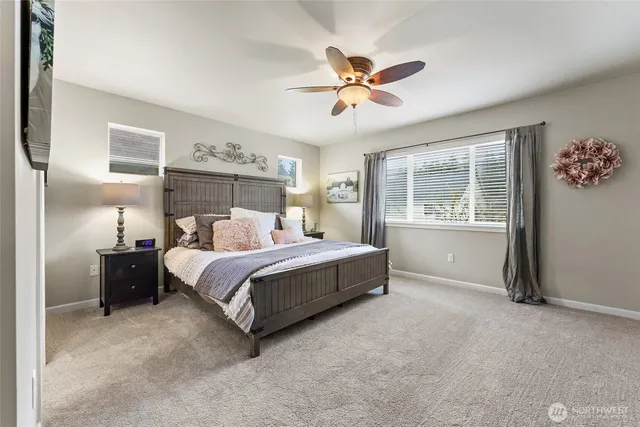an empty room with chandelier fan and windows
