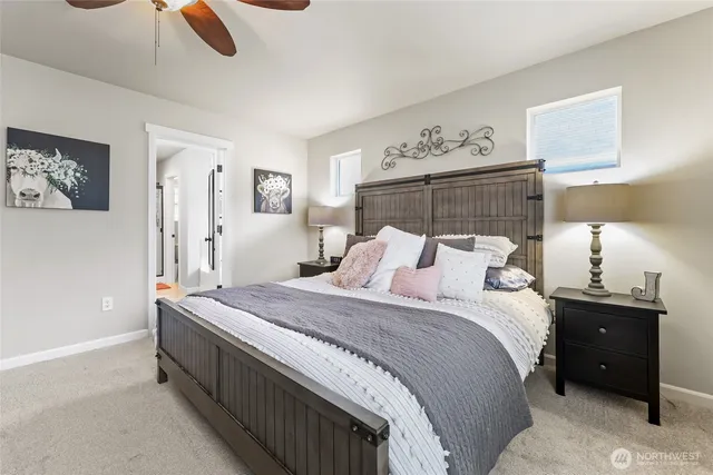 an empty room with a chandelier fan and windows