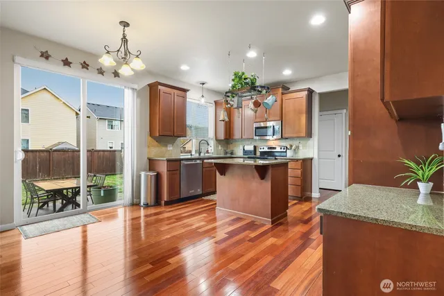 a kitchen with stainless steel appliances granite countertop a sink a stove and a refrigerator