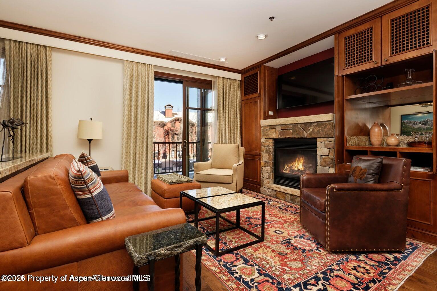 39 Boomerang Road, Unit 83119 Aspen, CO 81611 - Photo 2 of 16 a living room with furniture fireplace and flat screen tv
