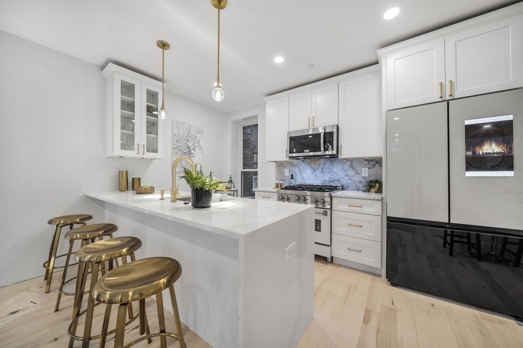 340 Meridian Street, Unit 1 Boston, MA 02128 - Photo 6 of 24 a kitchen with stainless steel appliances granite countertop a sink a stove and a refrigerator
