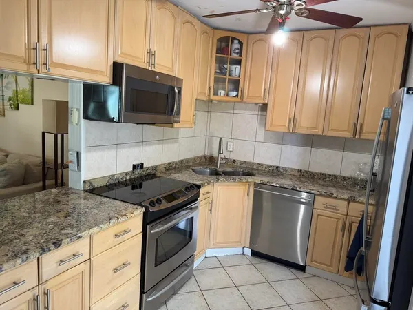 a kitchen with stainless steel appliances granite countertop a stove a sink and a microwave