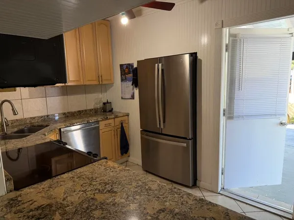 a kitchen with stainless steel appliances granite countertop a refrigerator a stove a sink and a microwave