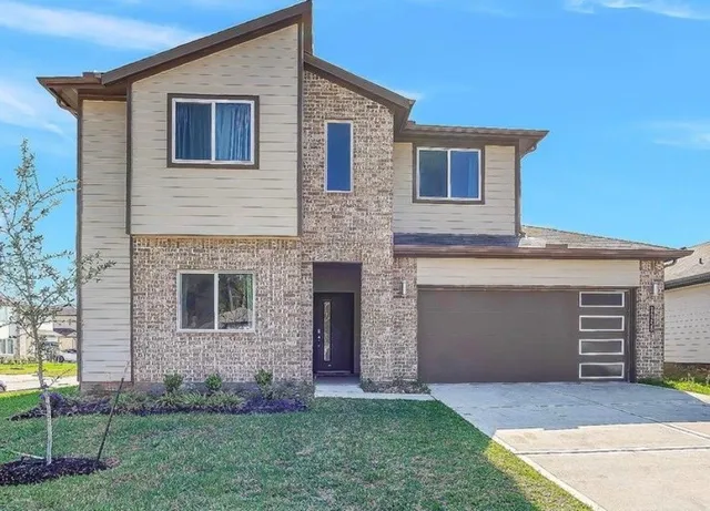 a front view of a house with a yard and garage