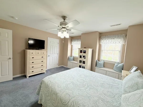 a large bedroom with a bed and flat tv