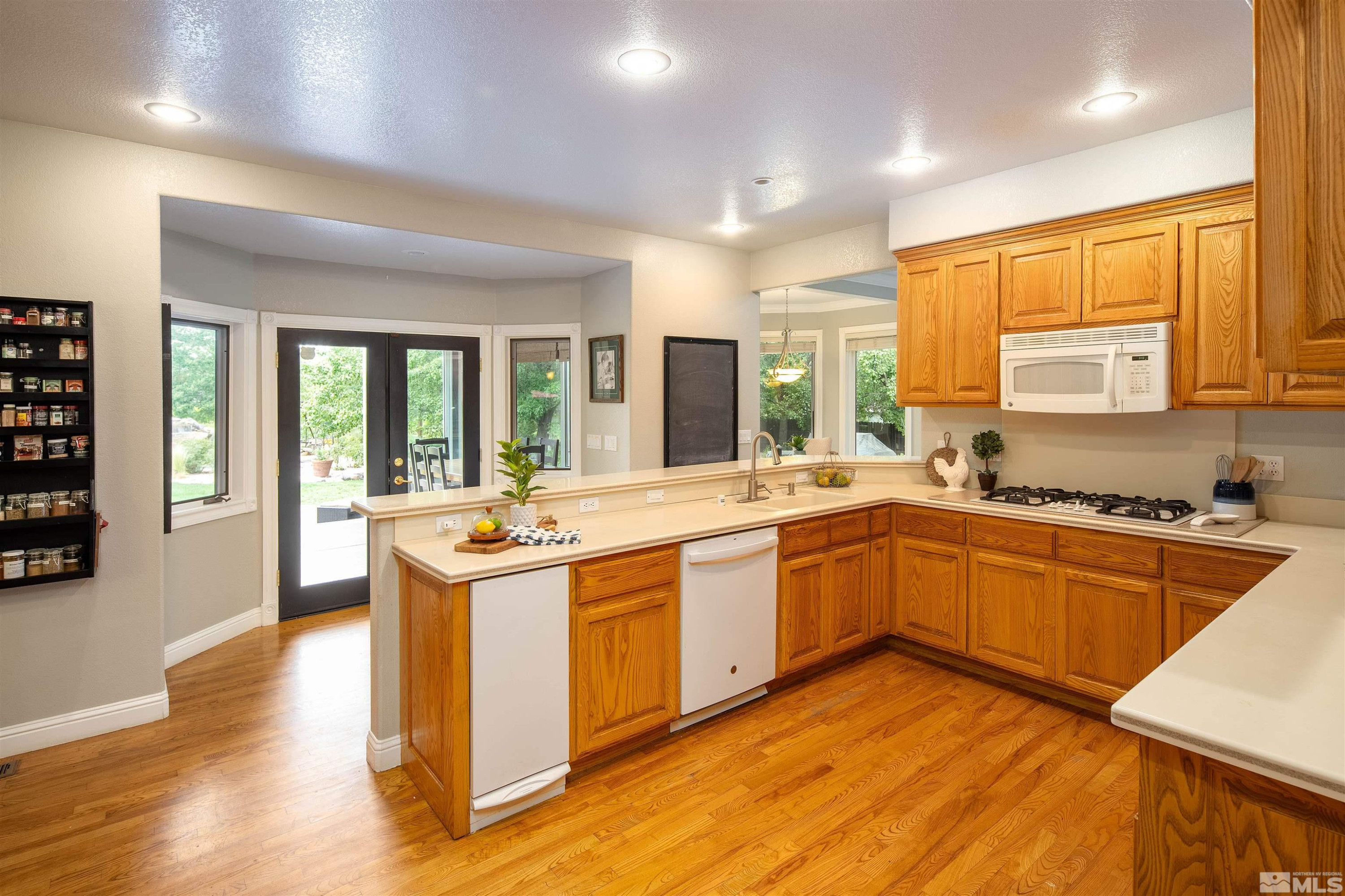 2032 Ash Canyon Road Carson City, NV 89703 - Photo 14 of 37 a kitchen with stainless steel appliances granite countertop sink stove and wooden cabinets