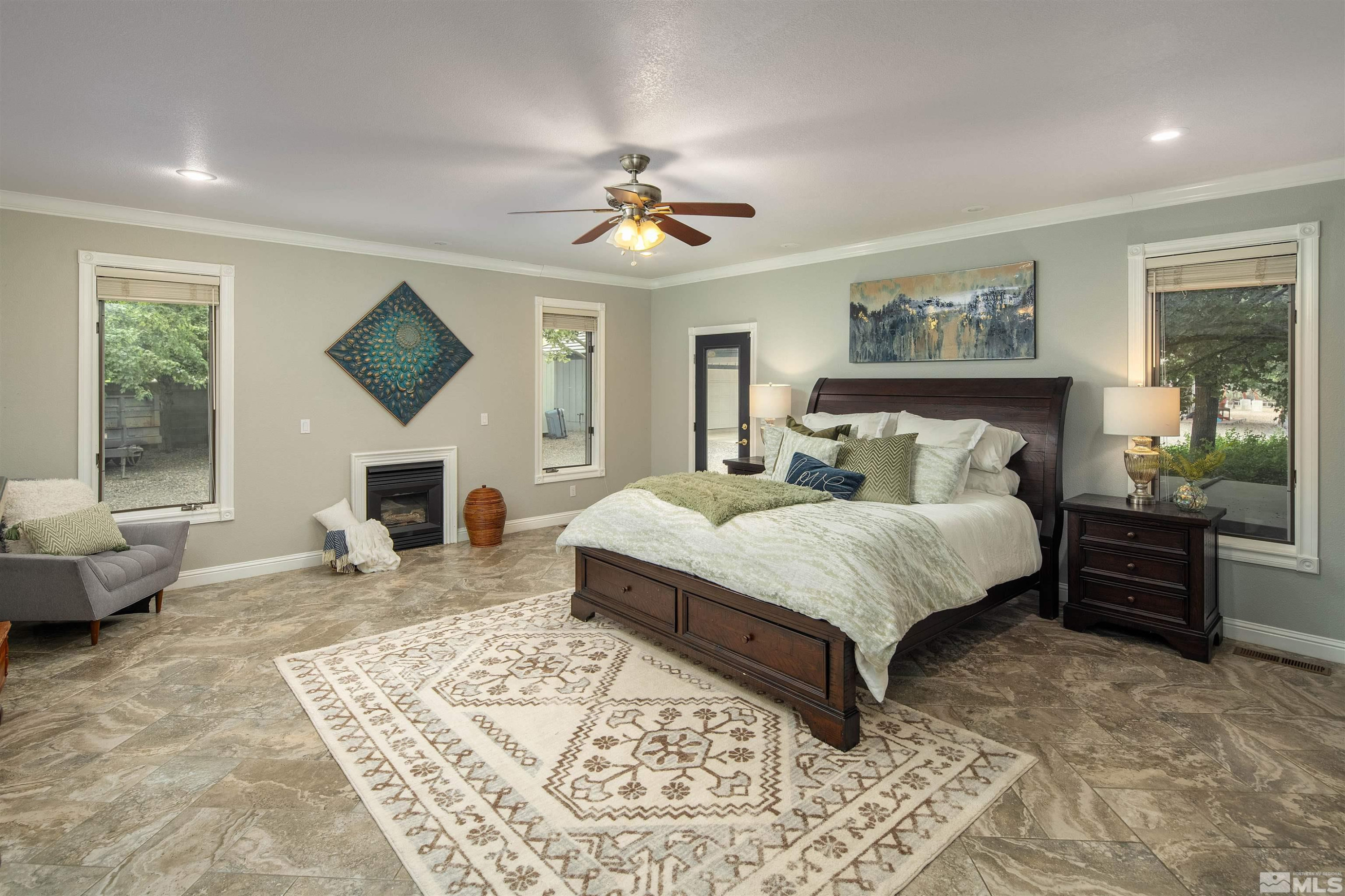 2032 Ash Canyon Road Carson City, NV 89703 - Photo 6 of 37 a spacious bedroom with a balcony a bed and a fireplace