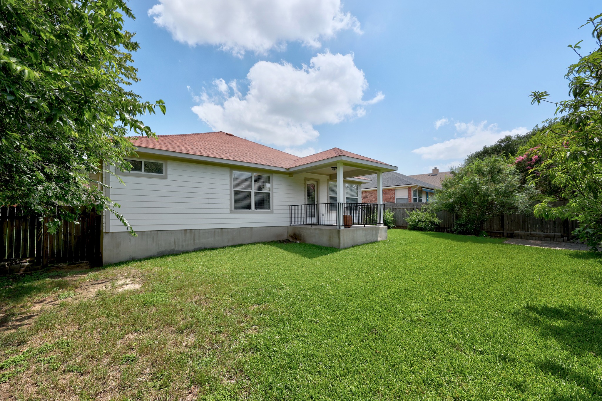 1108 Springbrook Road Pflugerville, TX 78660 - Photo 28 of 37 A generous lawn extends from a covered back patio, perfect for outdoor relaxation and entertaining.
