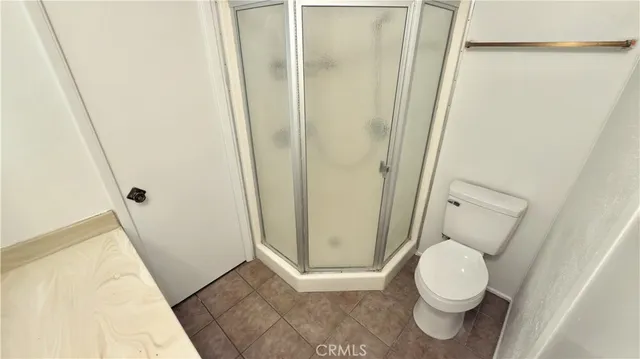 a white toilet sitting next to a shower