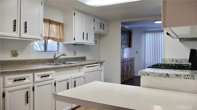 a kitchen with stainless steel appliances a sink stove and cabinets