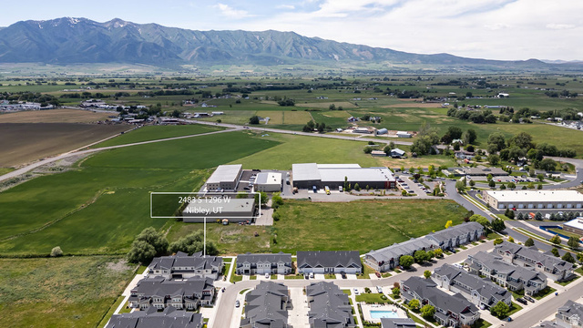 2483 South 1296th Street West Logan, UT 84321 - Photo 40 of 45 Aerial perspective showcasing a mixed-use landscape with agricultural fields, residential developments, and commercial structures
