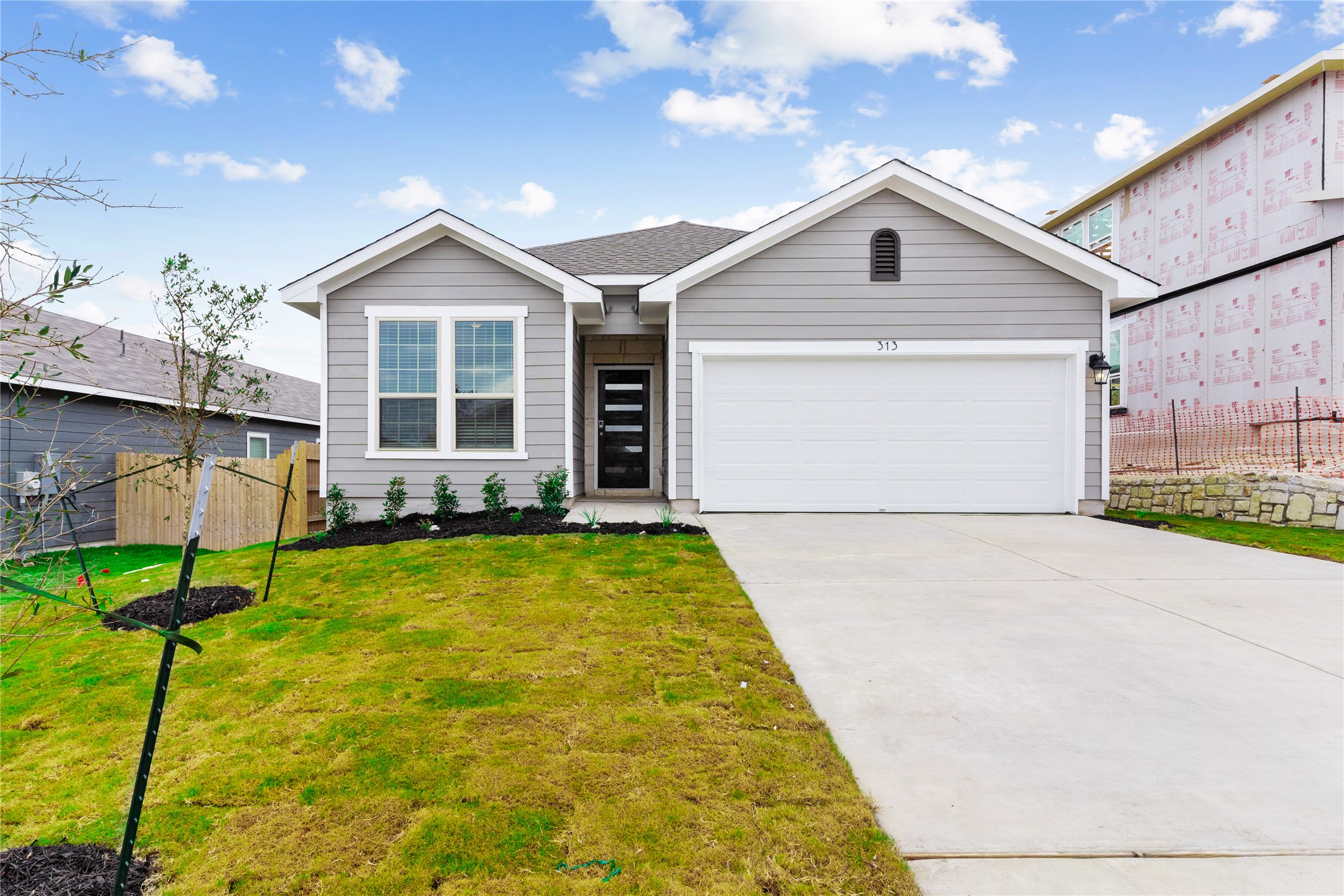 313 Mclintock Road Jarrell, TX 76537 - Photo 1 of 17 A newly constructed residence boasts a clean, contemporary façade with a welcoming concrete driveway.