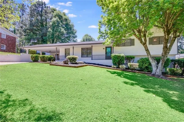 front view of a house with a yard and sitting area