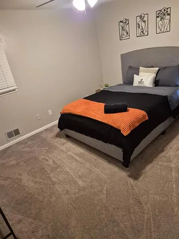 a bedroom with a bed and painting on the wall