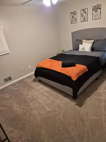 a bedroom with a bed and painting on the wall