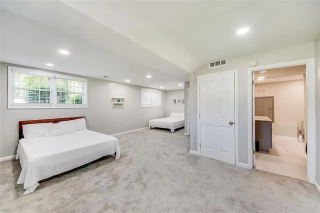 a spacious bedroom with a bed and a large window