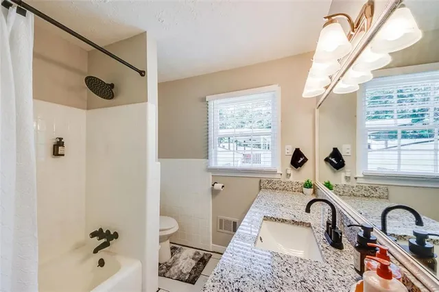 a bathroom with a tub sink and mirror