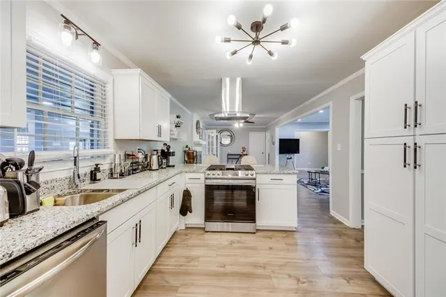 a large white kitchen with a stove and a sink