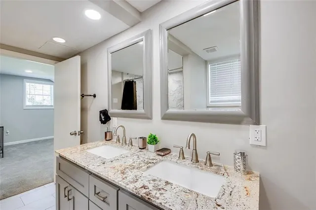 a bathroom with double vanity sinks and a mirror