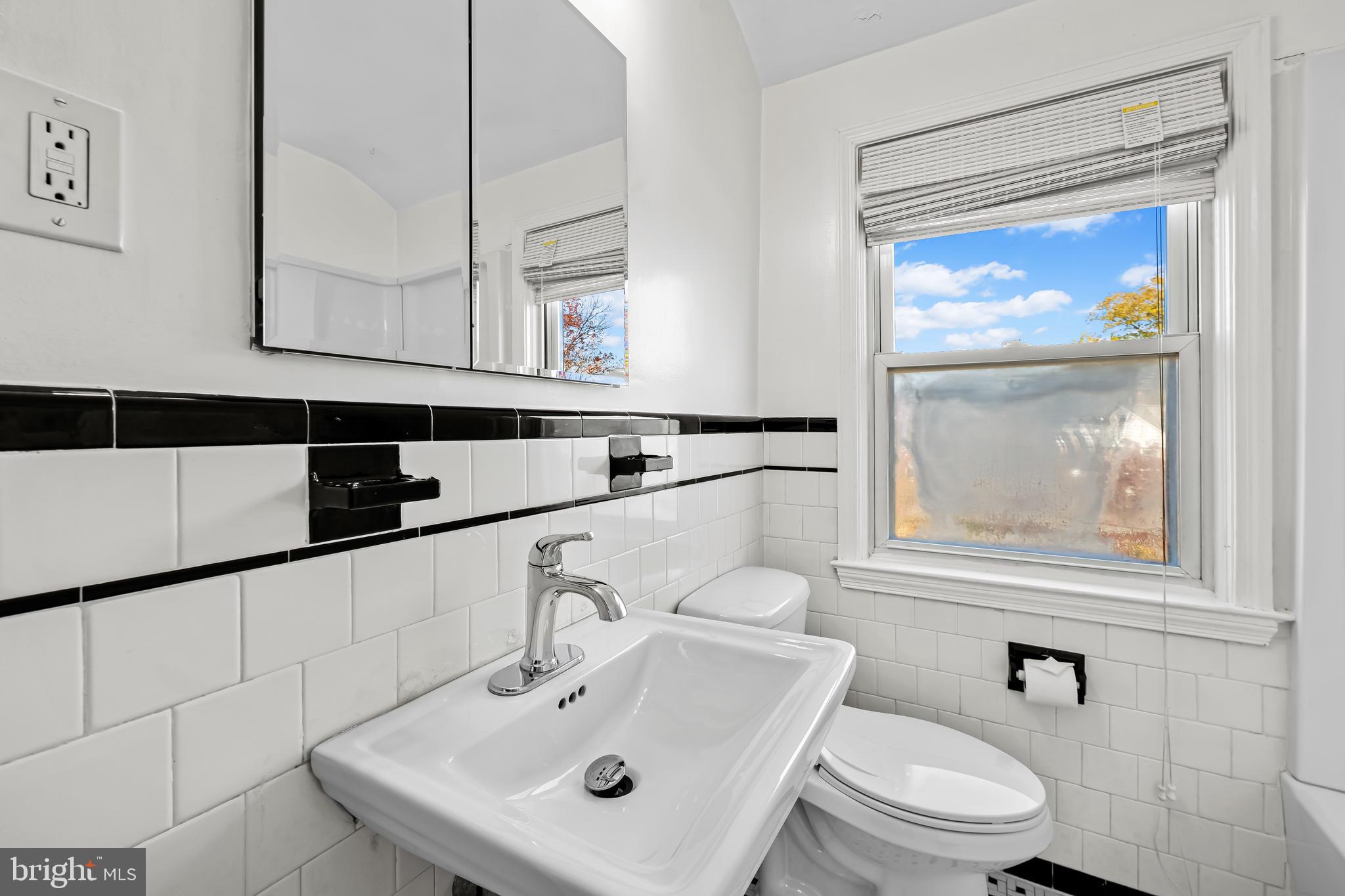 1027 Evesham Avenue Baltimore, MD 21212 - Photo 22 of 39 a bathroom with a sink a mirror and a toilet