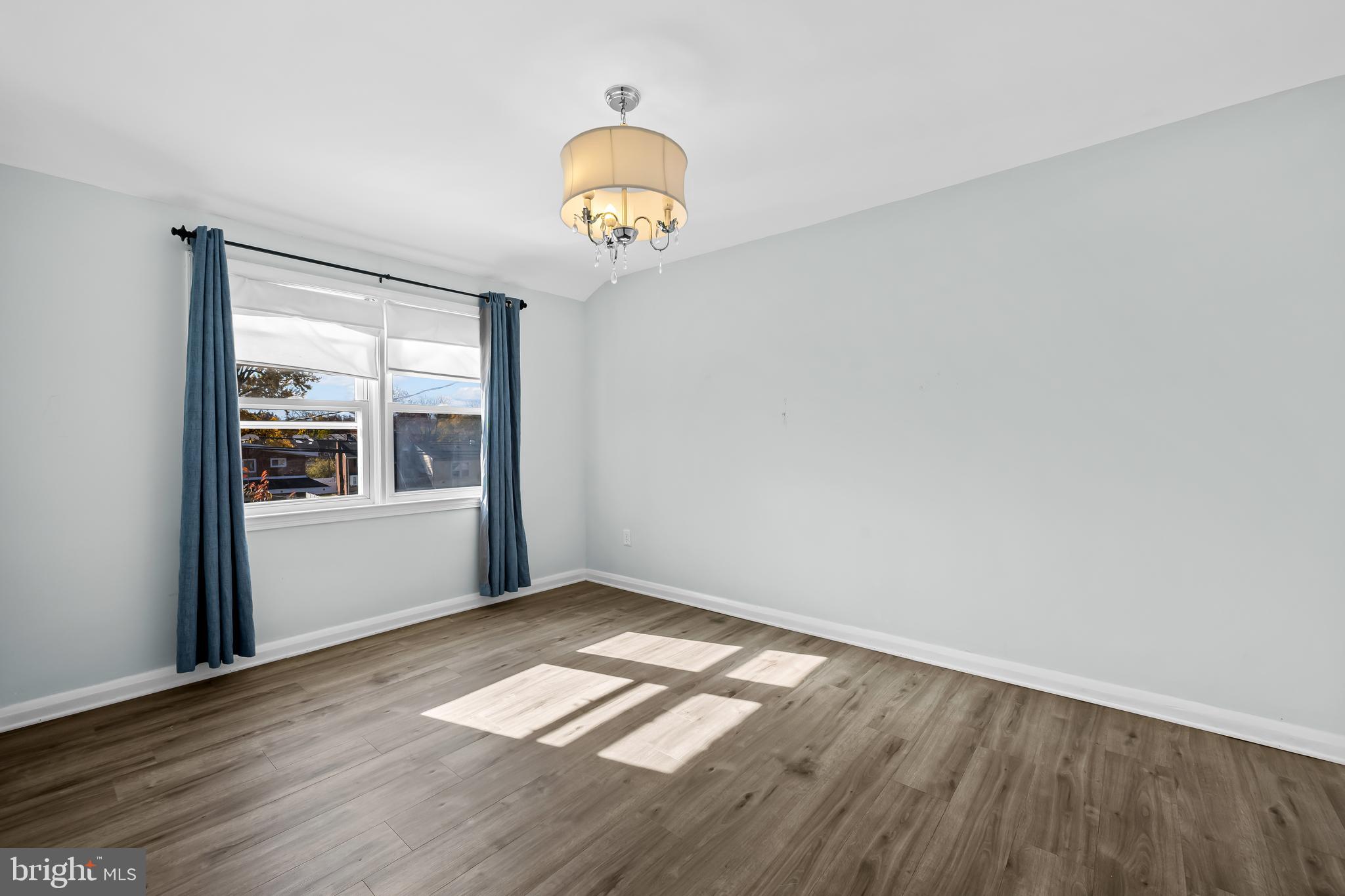 1027 Evesham Avenue Baltimore, MD 21212 - Photo 27 of 39 an empty room with wooden floor and windows