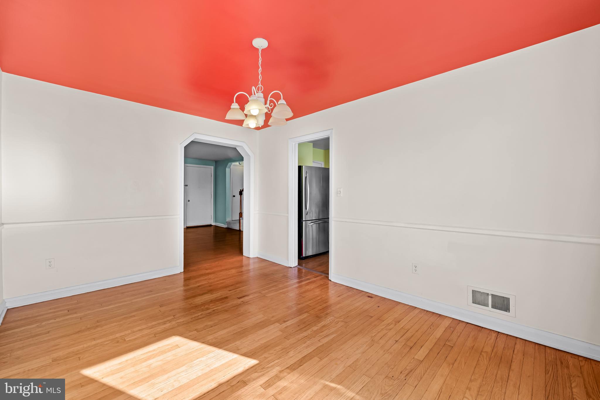 1027 Evesham Avenue Baltimore, MD 21212 - Photo 8 of 39 a view of a hallway with wooden floor and a chandelier