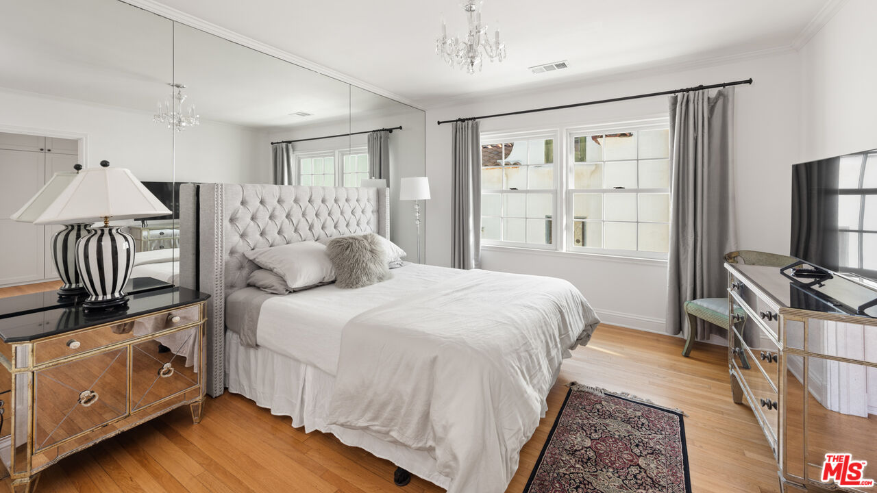 605 Palisades Beach Road Santa Monica, CA 90402 - Photo 32 of 33 a bedroom with a bed wooden floor and flat screen tv