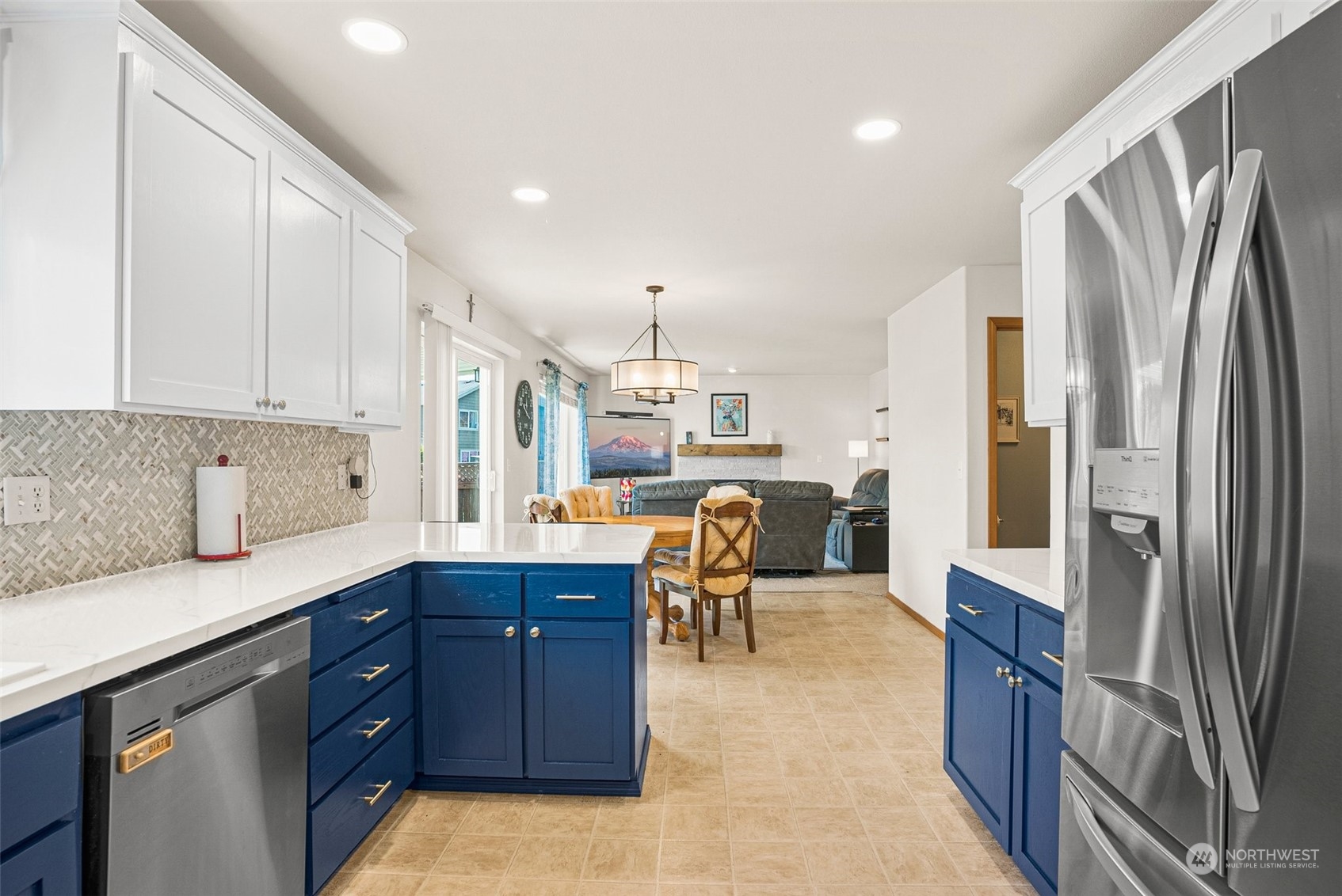 6642 Compass Street Southeast Lacey, WA 98513 - Photo 12 of 40 a kitchen with stainless steel appliances granite countertop a refrigerator a sink dishwasher a stove and a dining table with wooden floor
