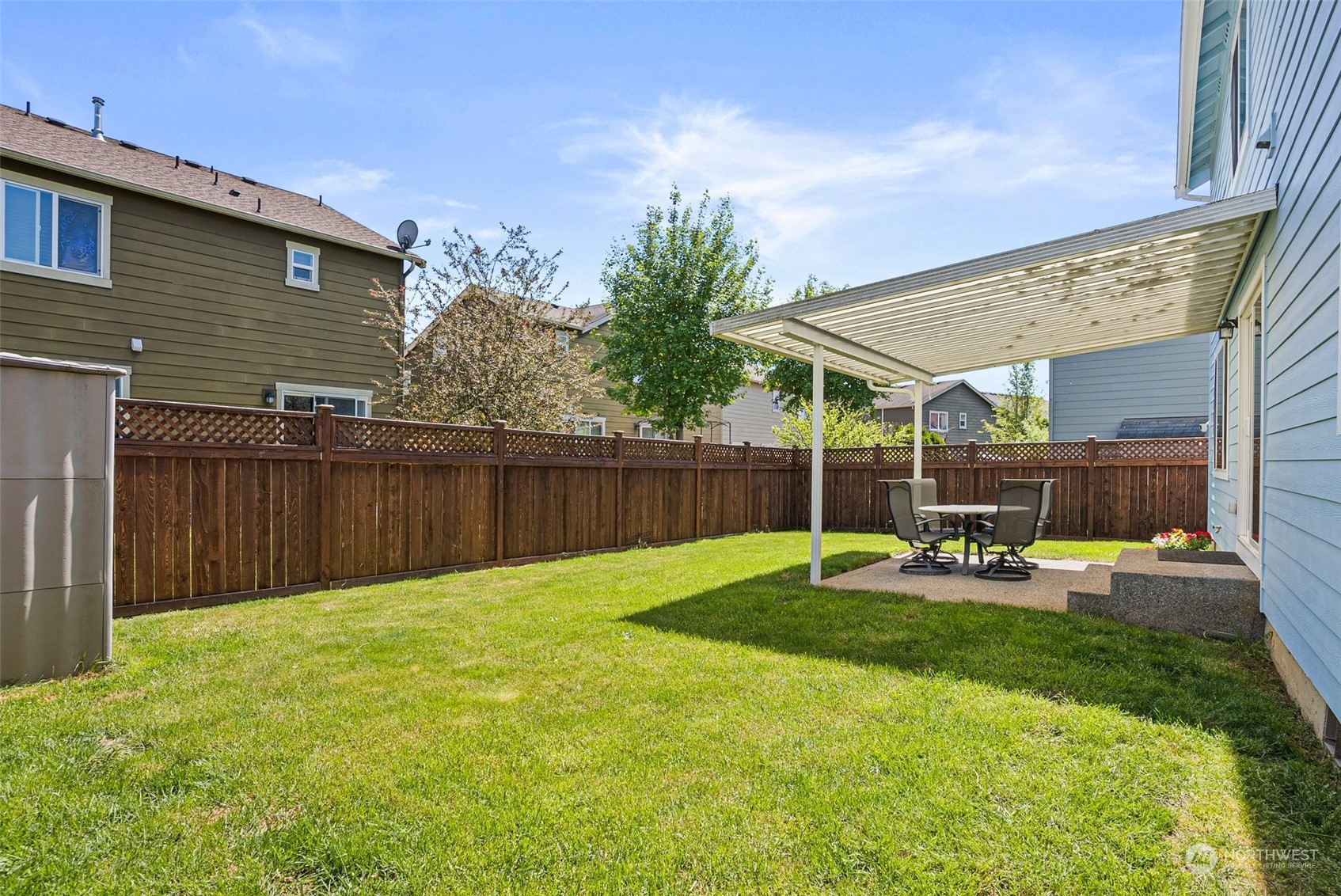 6642 Compass Street Southeast Lacey, WA 98513 - Photo 35 of 40 a view of a backyard with table and chairs and wooden fence