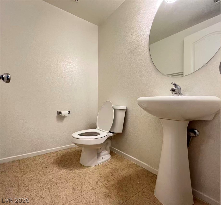 11143 Ranch Valley Street Las Vegas, NV 89179 - Photo 10 of 23 Functional full bathroom featuring a convenient pedestal sink and clean toilet.