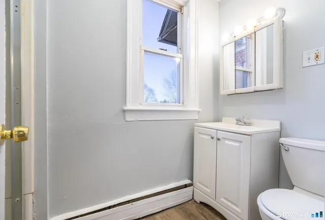 a bathroom with a toilet sink and mirror
