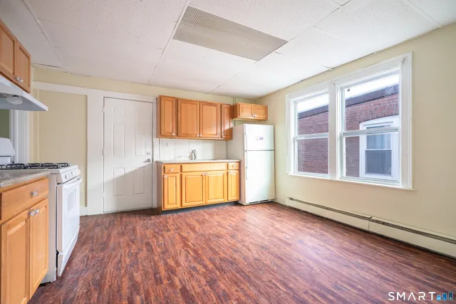 a view of a kitchen with wooden floor and electronic appliances