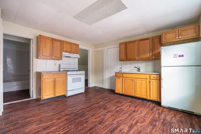 a kitchen with wooden floors and appliances