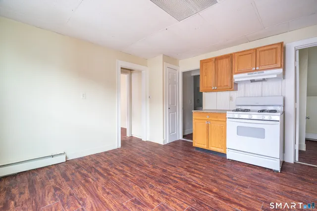 a kitchen with a stove cabinets and wooden floor