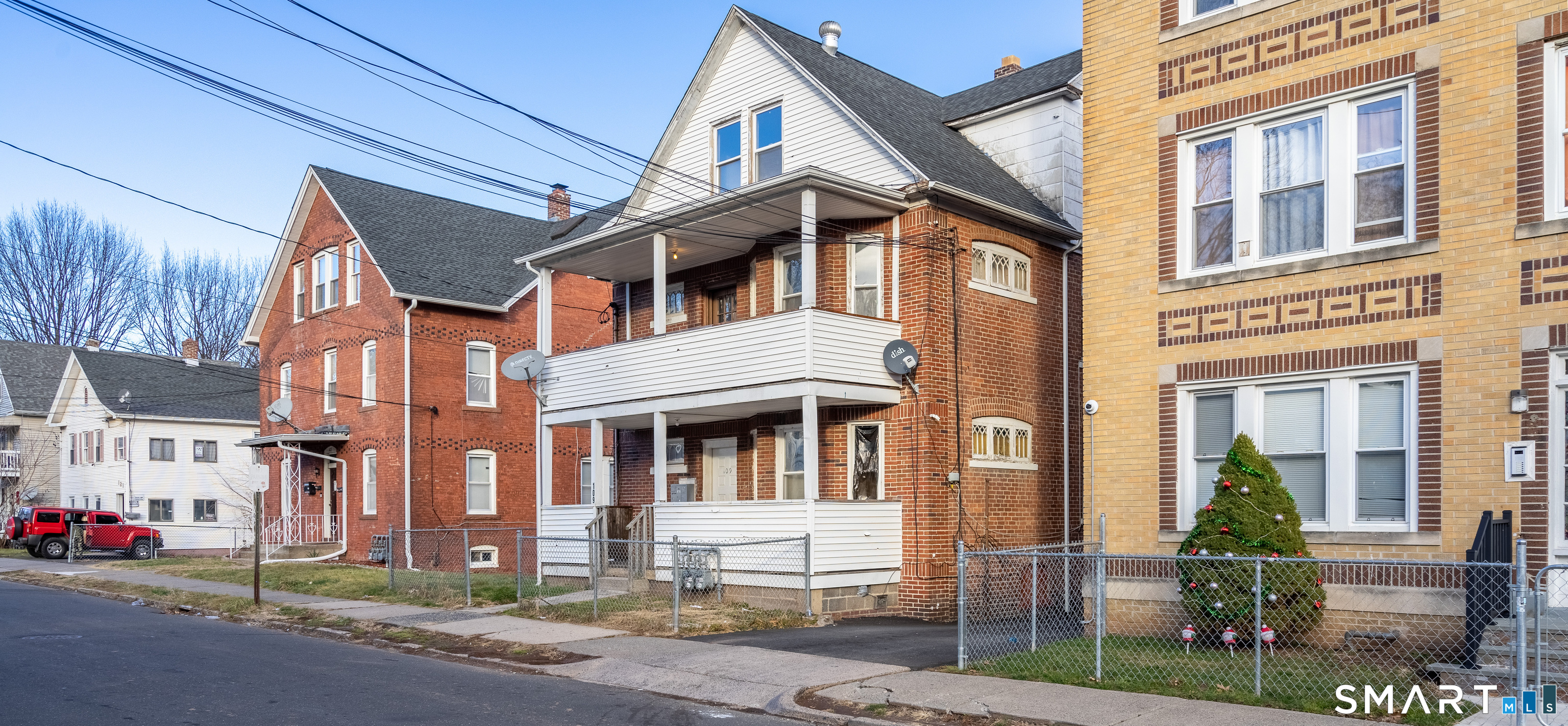 109 Clark Street New Britain, CT 06051 - Photo 3 of 24 a front view of a residential apartment building with a yard