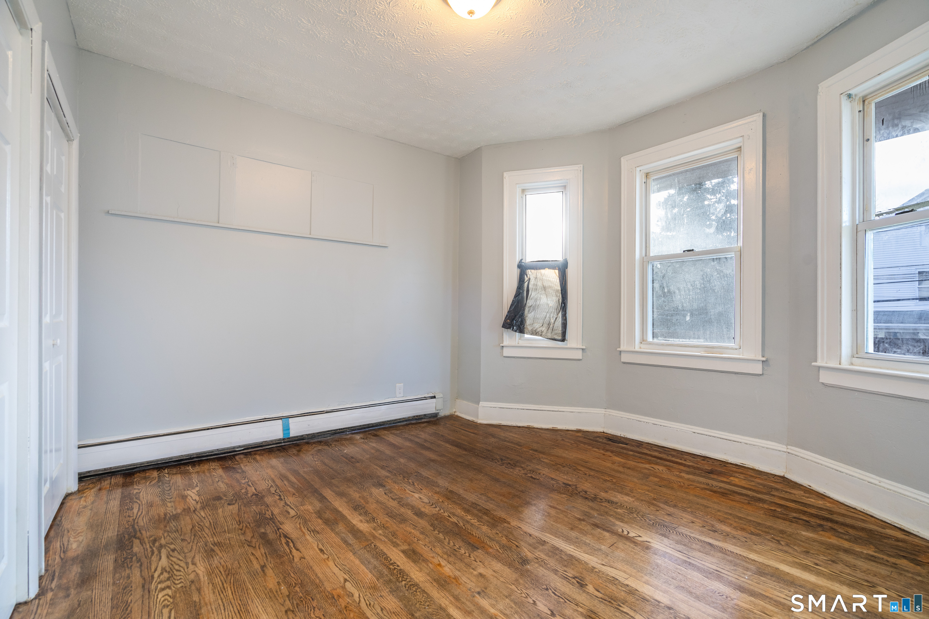 109 Clark Street New Britain, CT 06051 - Photo 6 of 24 an empty room with wooden floor and windows