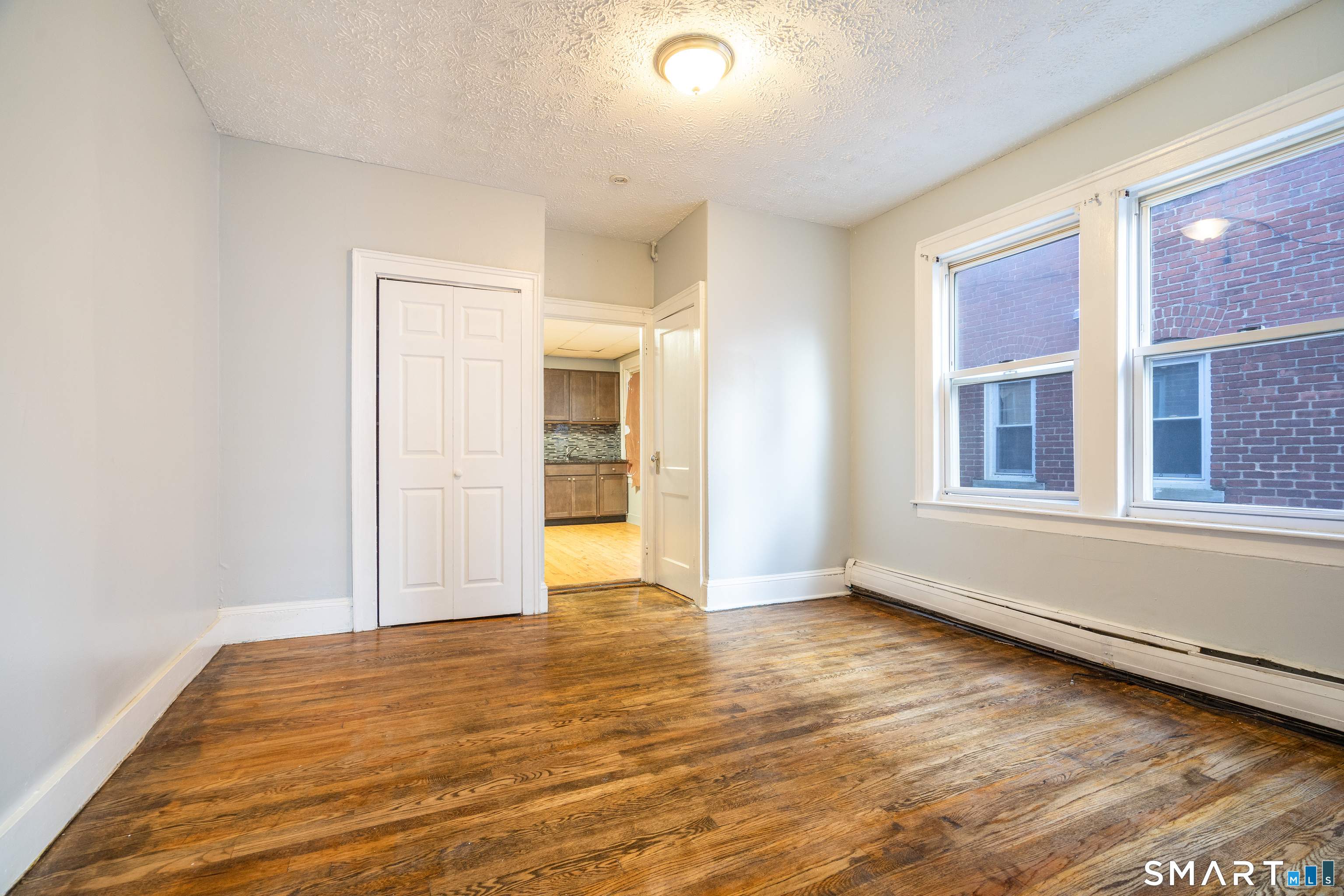 109 Clark Street New Britain, CT 06051 - Photo 8 of 24 a view of an empty room with window and wooden floor