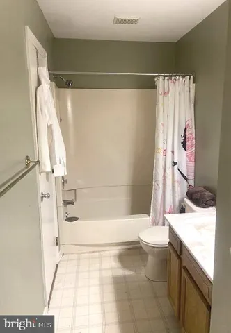 a bathroom with a granite countertop sink a toilet and shower