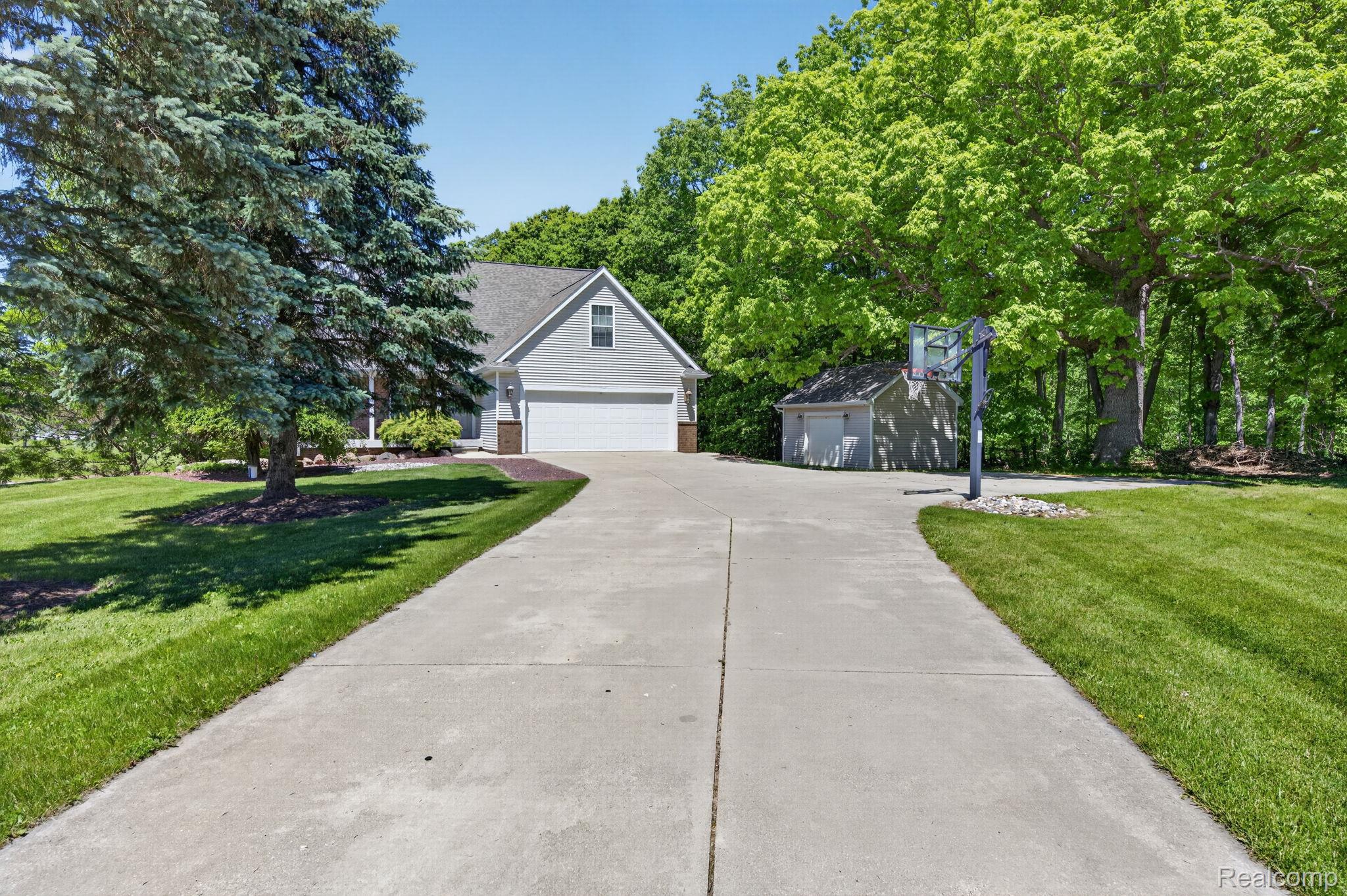 9055 Hegel Road Grand Blanc, MI 48439 - Photo 5 of 62 Expansive concrete driveway leading to a two-car garage
