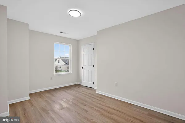 an empty room with wooden floor and window