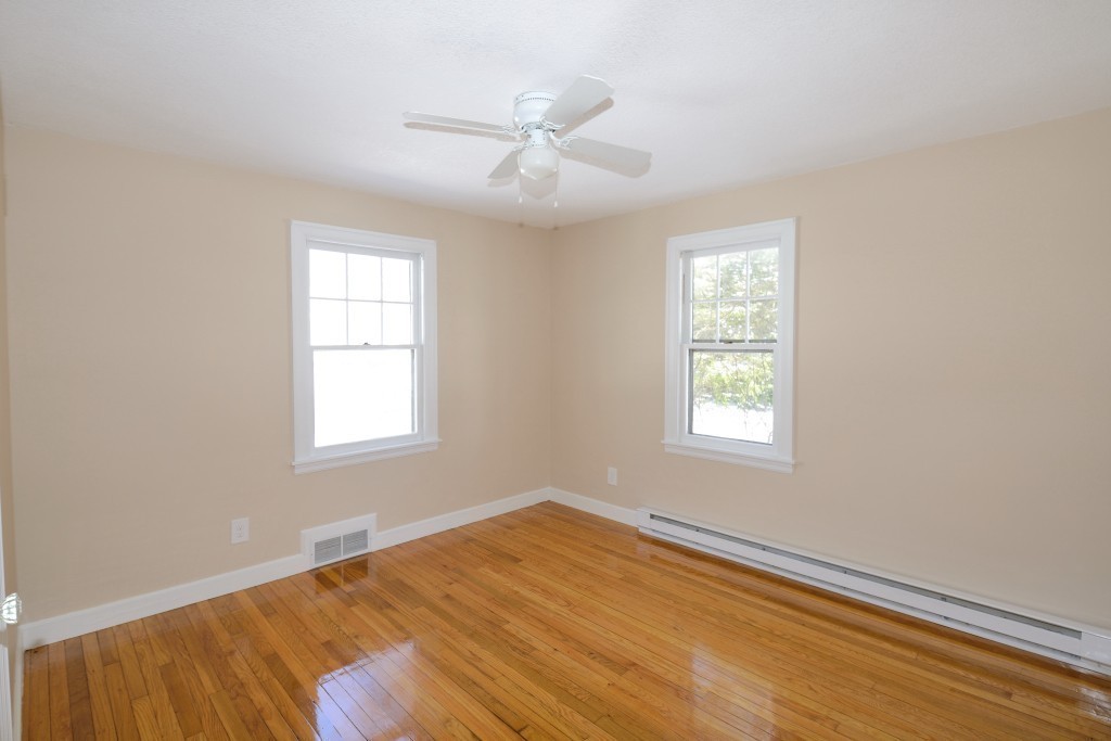 155 Carroll Street Springfield, MA 01108 - Photo 6 of 15 an empty room with wooden floor ceiling fan and windows