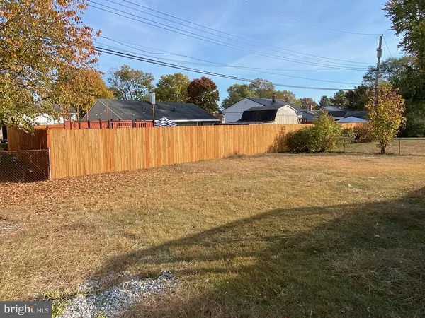 a backyard of a house with wooden deck and outdoor seating