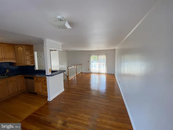 a large white kitchen with wooden floor and floors