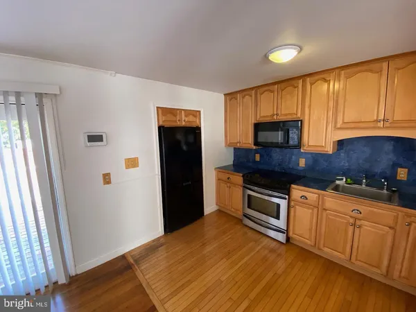 a kitchen with granite countertop a refrigerator stove top oven and sink
