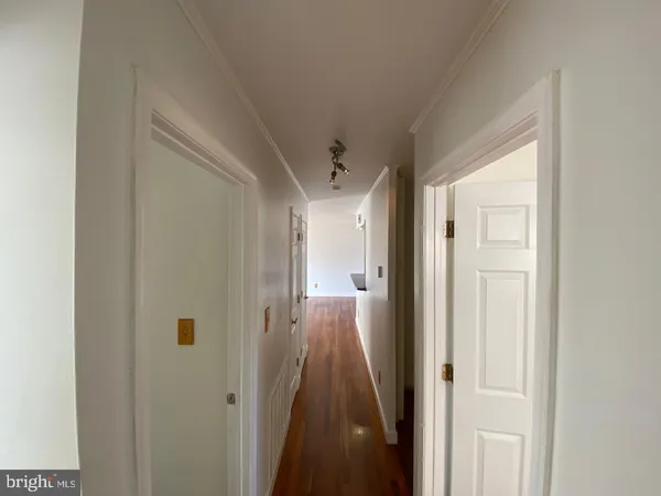 a view of a hallway with wooden floor and staircase